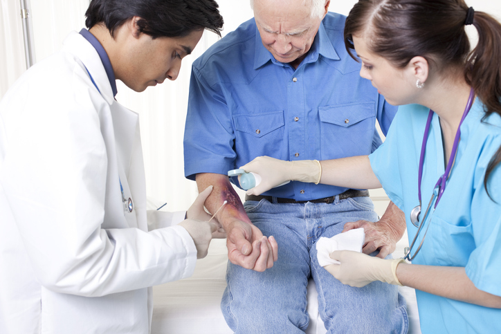 doctors cleaning a wound on a patient's arm