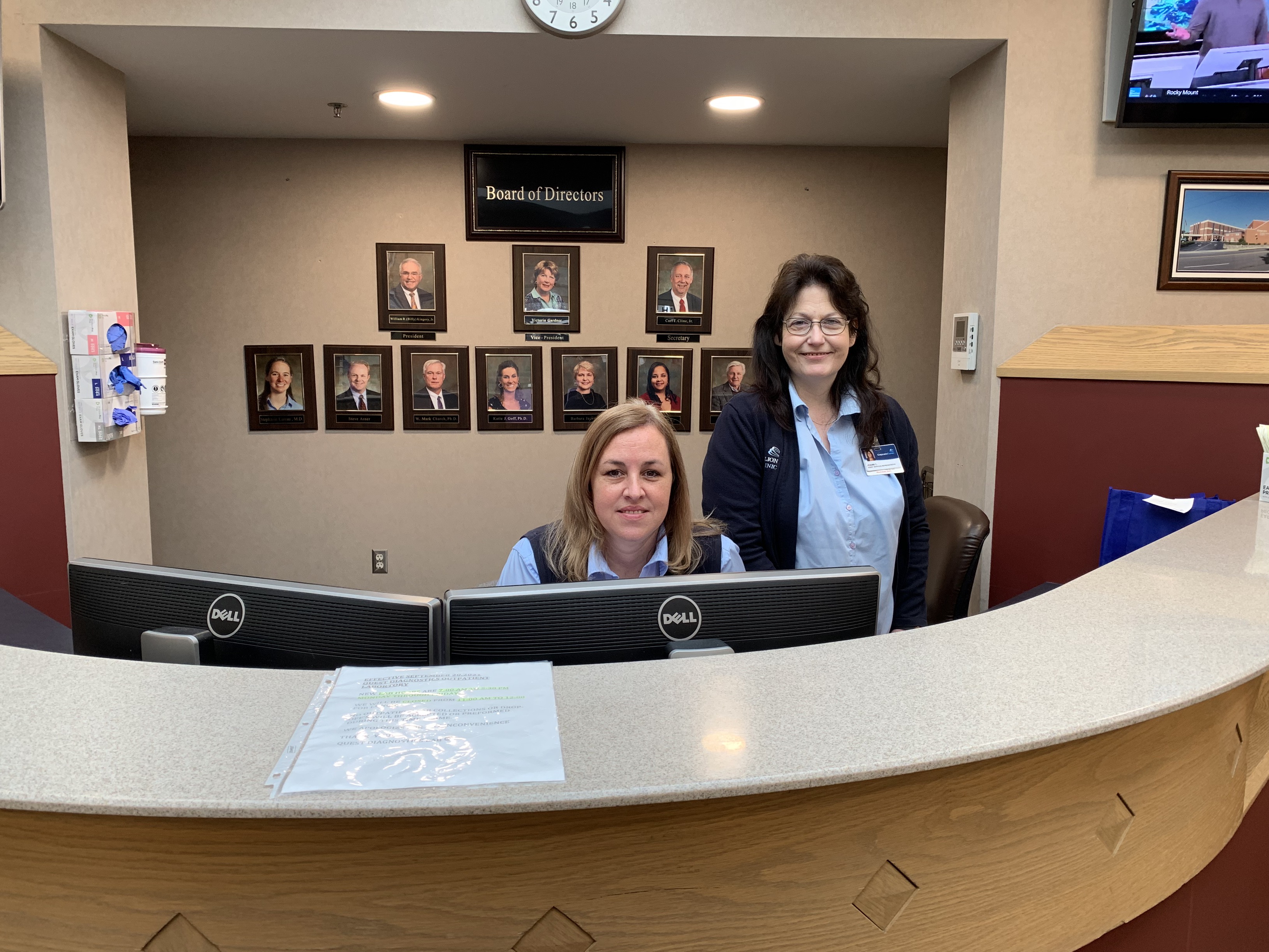 Volunteers at desk smiling and looking at camera