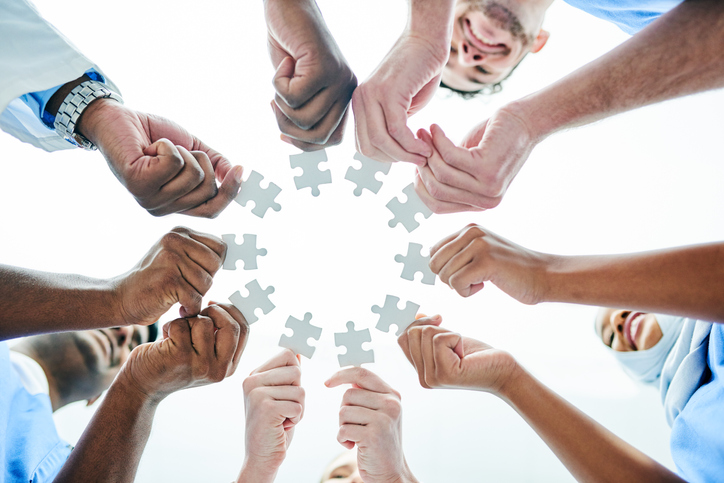 doctors in a circle holding puzzle pieces