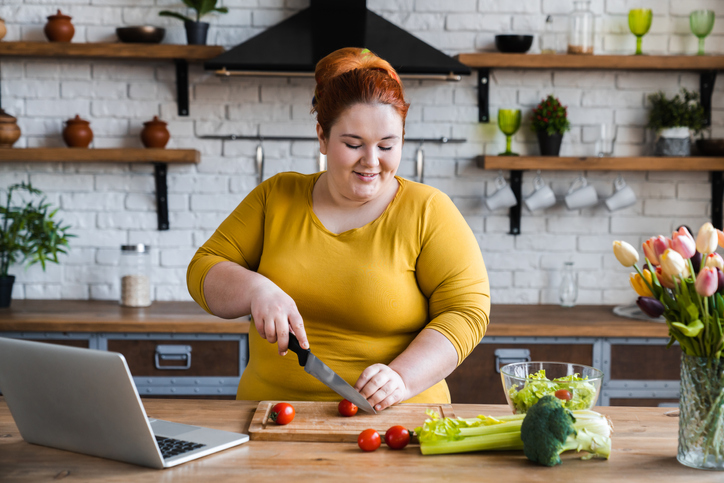 a woman cutting tomatoes in a kitchen