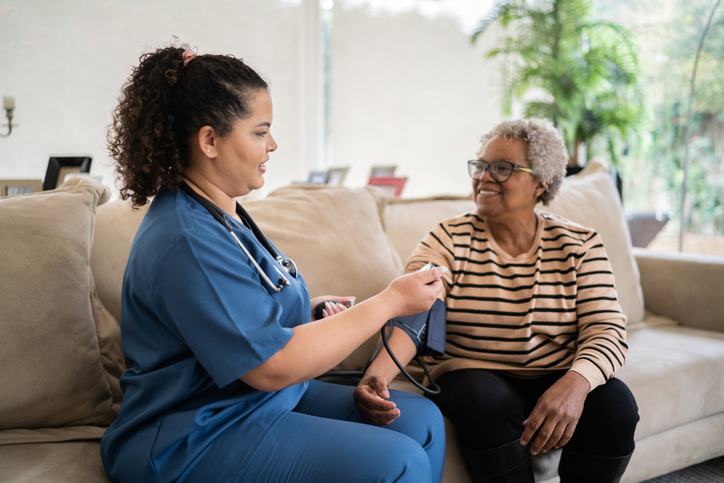 a nurse checking a woman's blood pressure