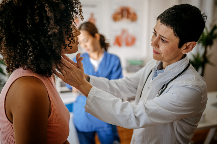 a doctor checking a patient's neck