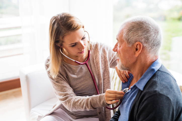 a nurse listening to a patient's heart
