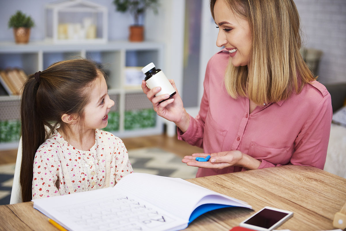 Mother giving young daughter medication