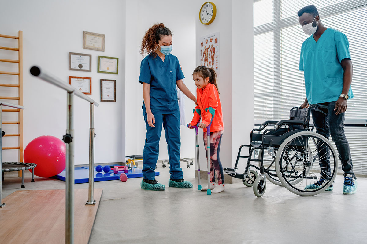 Young patient doing physiotherapy at a clinic with help of a therapists