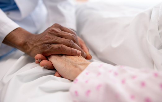 Patient and doctor holding hands