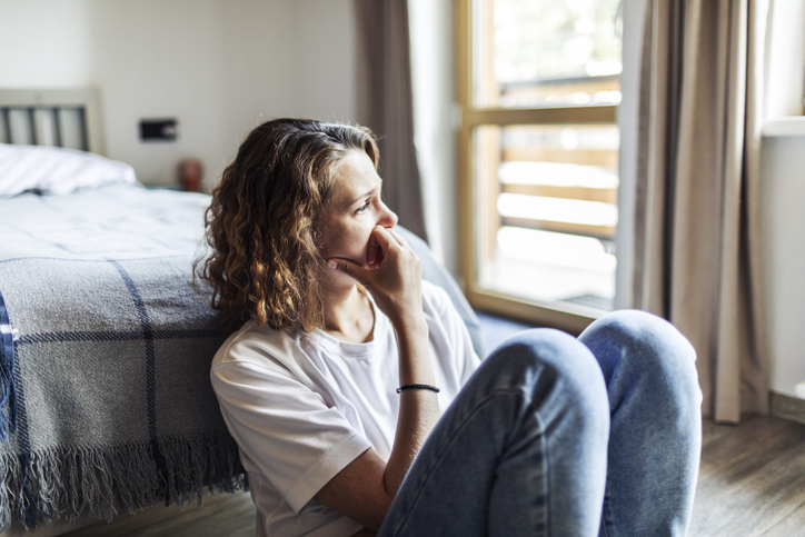 young woman staring out window
