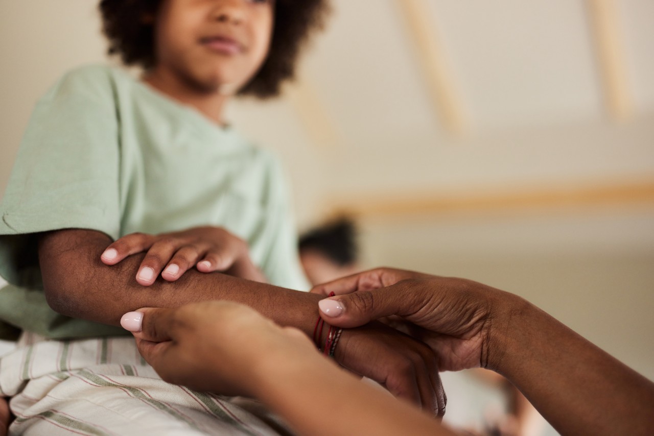 Close up of a mother examining her daughter's painful arm.